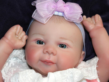 A baby doll lies on a purple blanket, evoking a sense of comfort and childhood innocence.